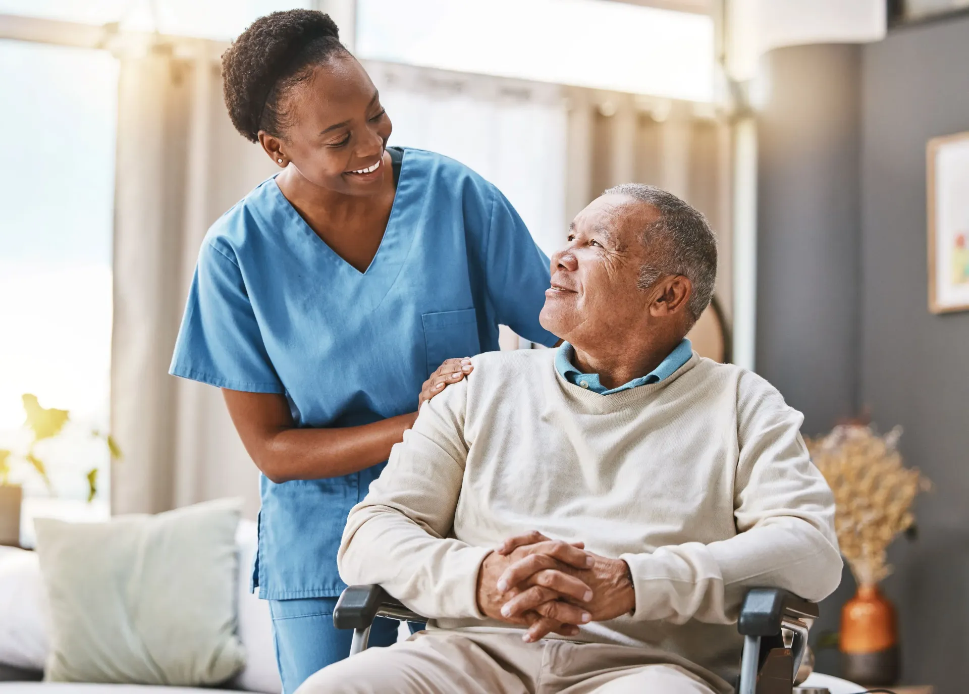 A smiling caregiver and an elderly male client sharing warm companionship