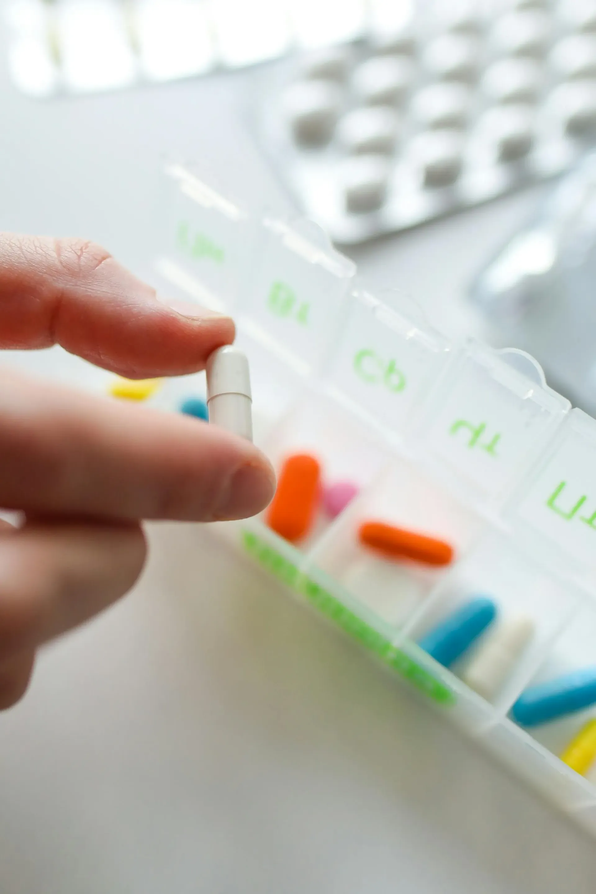 A hand organizing daily medication